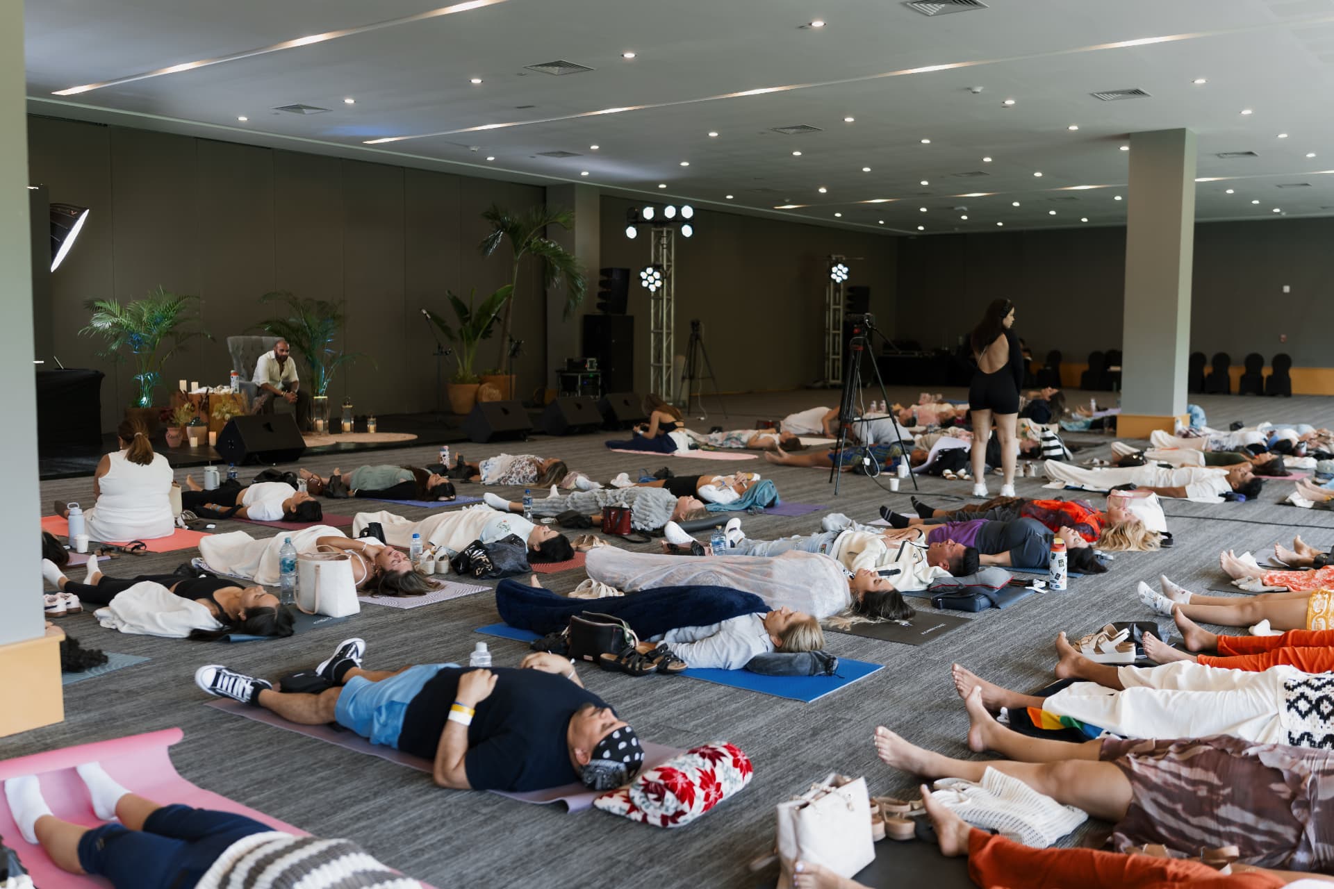 Sala completa del retiro en una práctica de relajación guiada.